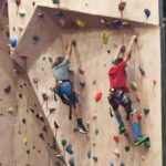 two kids climbing rock wall