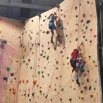 two kids climbing rock wall